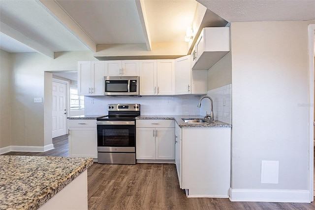 kitchen featuring tasteful backsplash, dark wood-style flooring, appliances with stainless steel finishes, and a sink