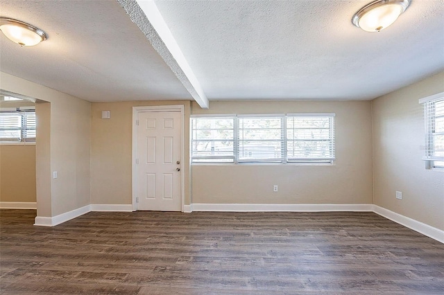 unfurnished room featuring baseboards, plenty of natural light, dark wood-type flooring, and a textured ceiling