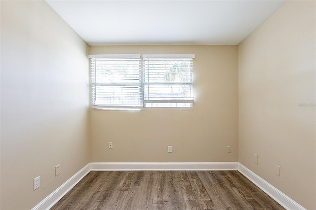 empty room featuring baseboards and wood finished floors