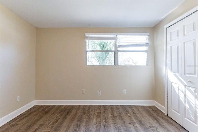 empty room featuring baseboards and wood finished floors