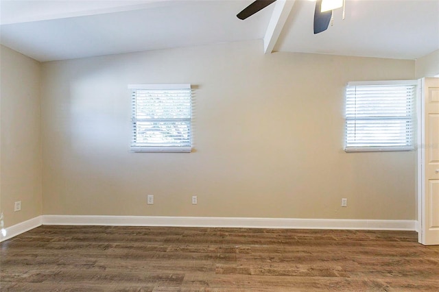 spare room featuring vaulted ceiling with beams, wood finished floors, and a wealth of natural light