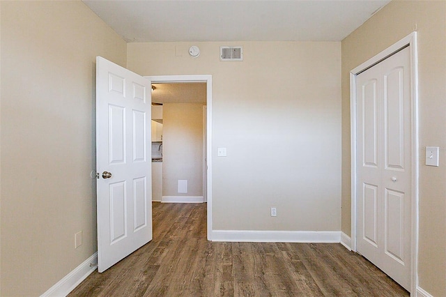 unfurnished bedroom with visible vents, baseboards, and wood finished floors