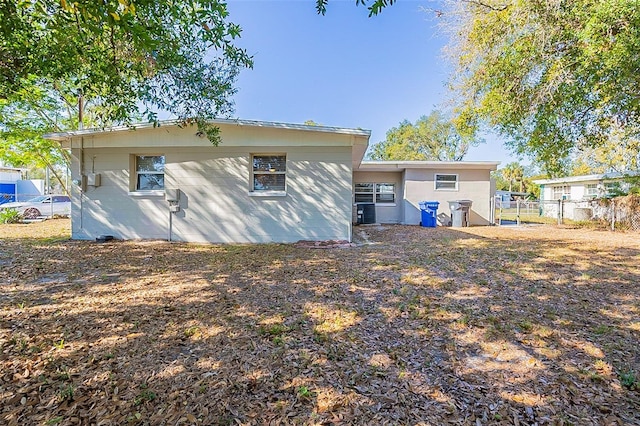 back of house featuring cooling unit and fence