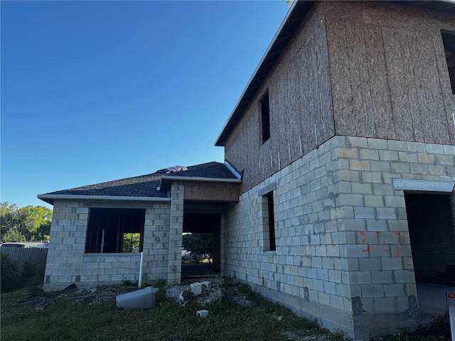 view of property exterior with a shingled roof