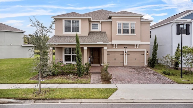 view of front of home with a garage, a shingled roof, decorative driveway, a front lawn, and stucco siding