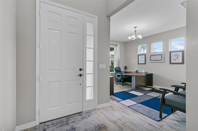 entrance foyer featuring an inviting chandelier, baseboards, and wood finished floors