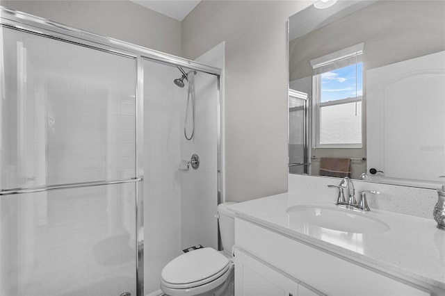 bathroom with toilet, a shower stall, and vanity