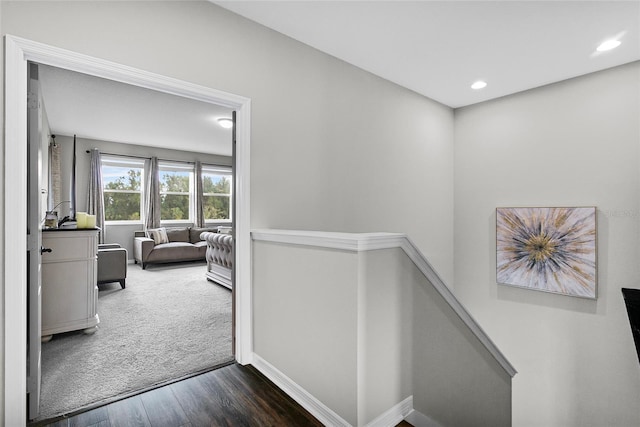 corridor with recessed lighting, baseboards, dark wood finished floors, and an upstairs landing