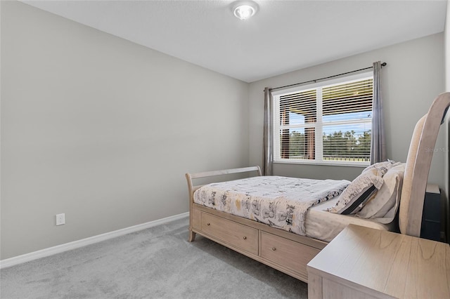 bedroom with baseboards and light colored carpet