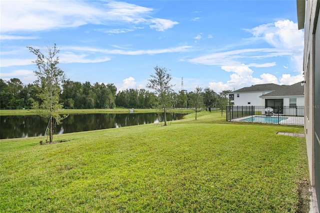 view of yard with a fenced in pool, a water view, and fence