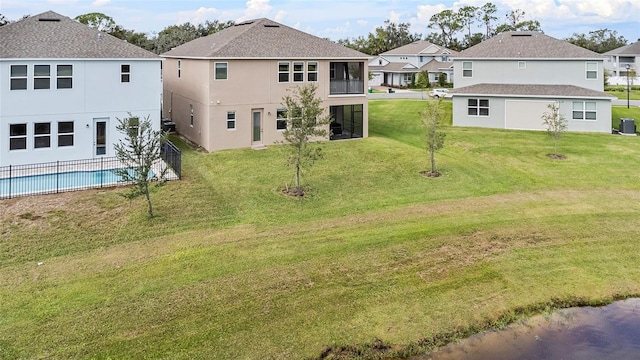 back of property featuring a fenced in pool, cooling unit, a yard, and stucco siding