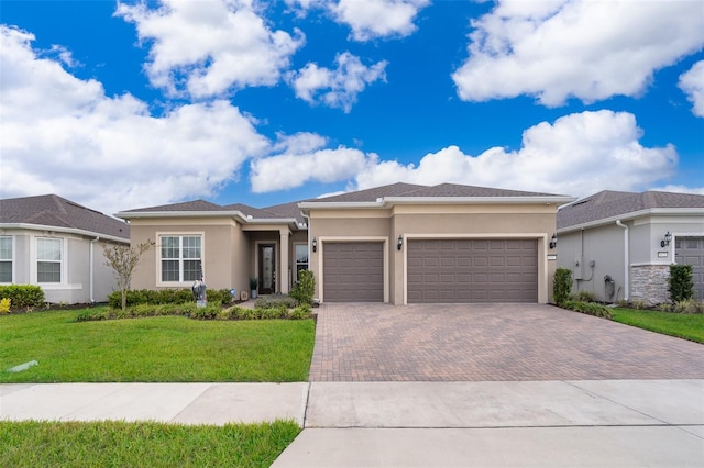 prairie-style house with an attached garage, a front yard, decorative driveway, and stucco siding