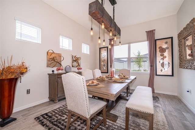 dining area featuring light wood-style flooring and baseboards