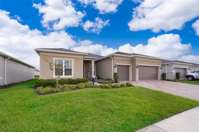 prairie-style home featuring a garage, a front yard, decorative driveway, and stucco siding