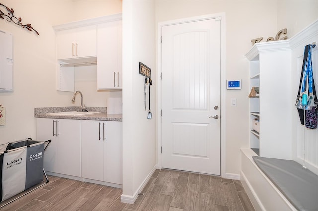 interior space featuring wood tiled floor, baseboards, and a sink