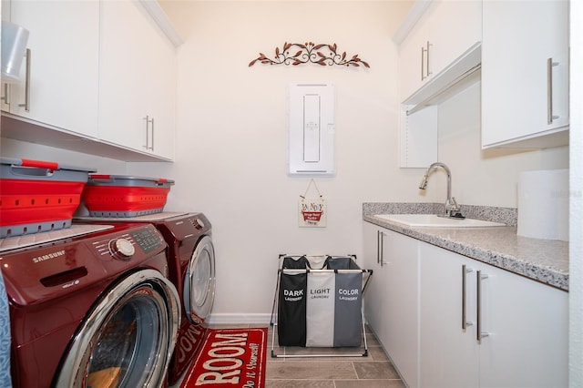 laundry area featuring cabinet space, electric panel, baseboards, washer and dryer, and a sink