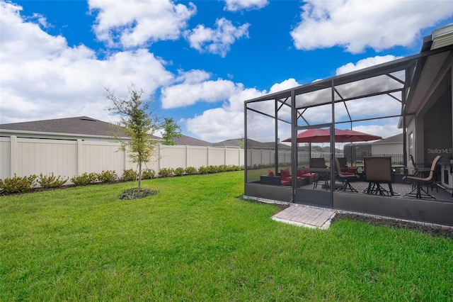 view of yard featuring a patio area, a fenced backyard, and glass enclosure