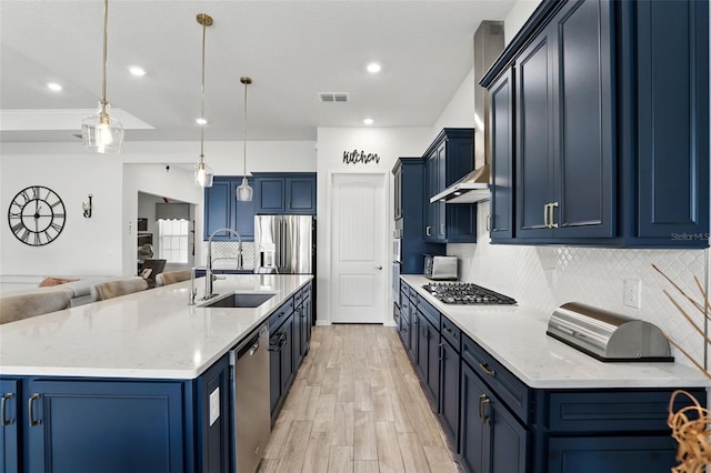 kitchen featuring a sink, blue cabinets, light wood-type flooring, appliances with stainless steel finishes, and visible vents