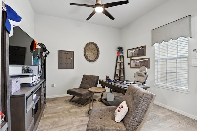 office area featuring baseboards, a ceiling fan, and light wood-style flooring