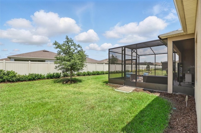 view of yard featuring a fenced backyard and glass enclosure