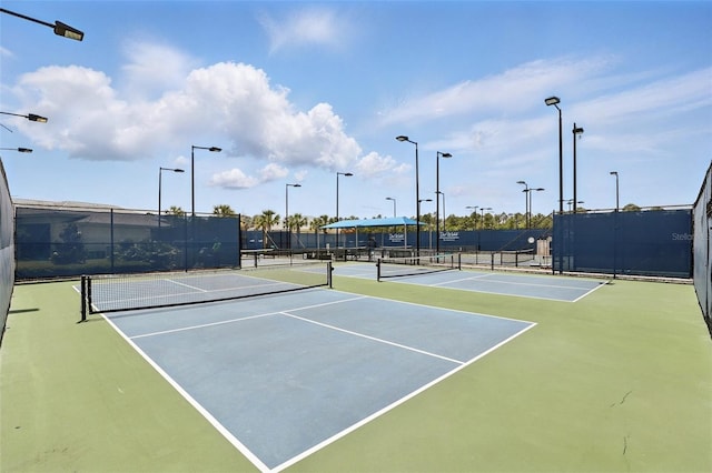 view of tennis court featuring fence and community basketball court