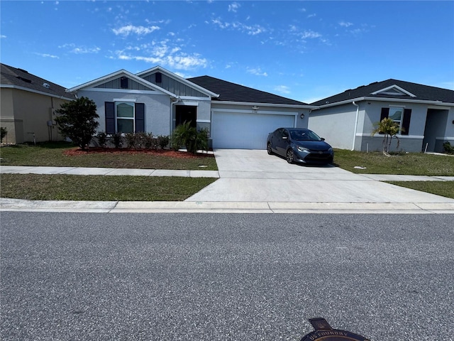 view of front of home featuring a front lawn, driveway, board and batten siding, and an attached garage