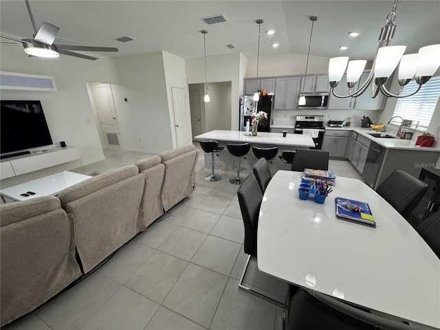 interior space featuring stainless steel appliances, gray cabinets, visible vents, open floor plan, and a sink