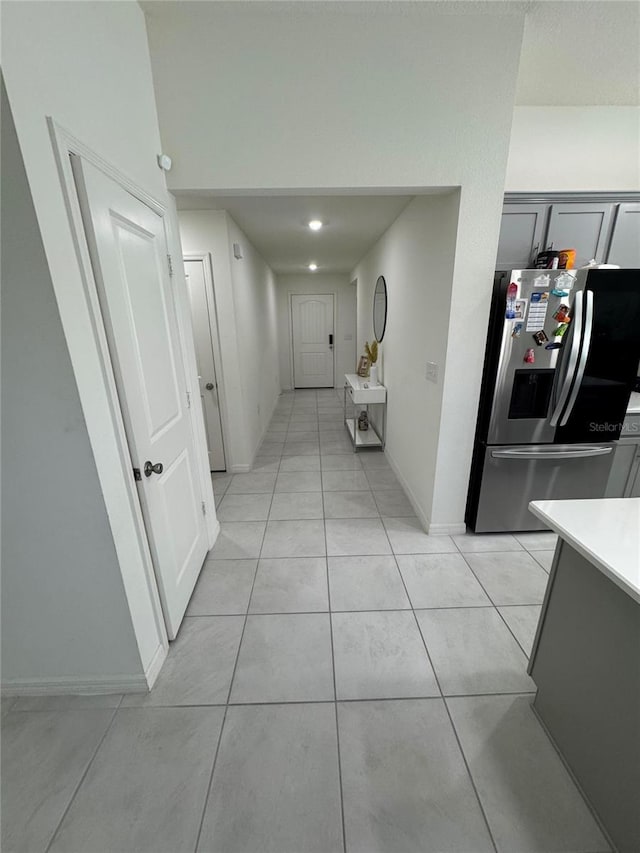 corridor with light tile patterned floors and baseboards