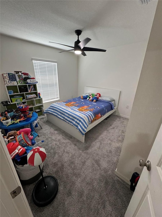 carpeted bedroom with a textured ceiling and a ceiling fan