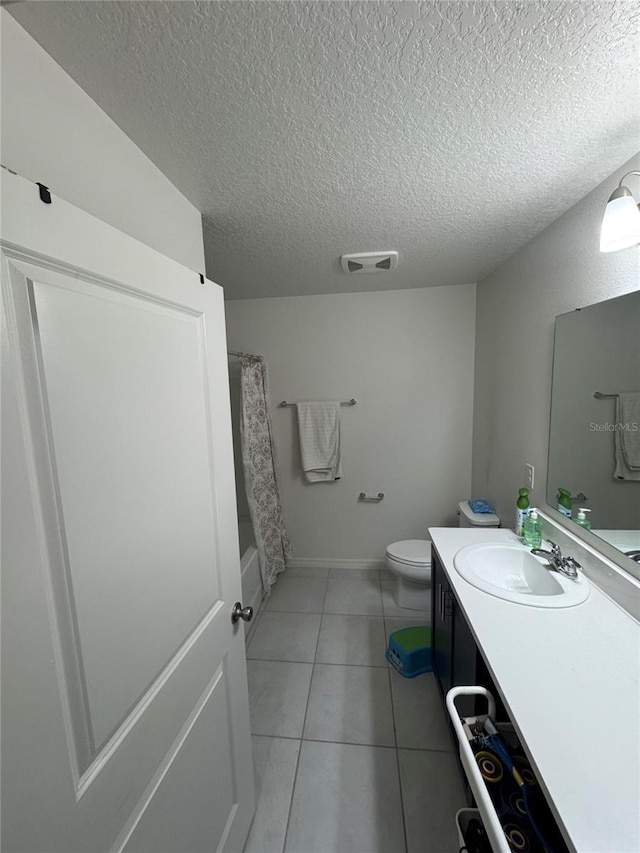 full bathroom with a textured ceiling, vanity, toilet, and tile patterned floors