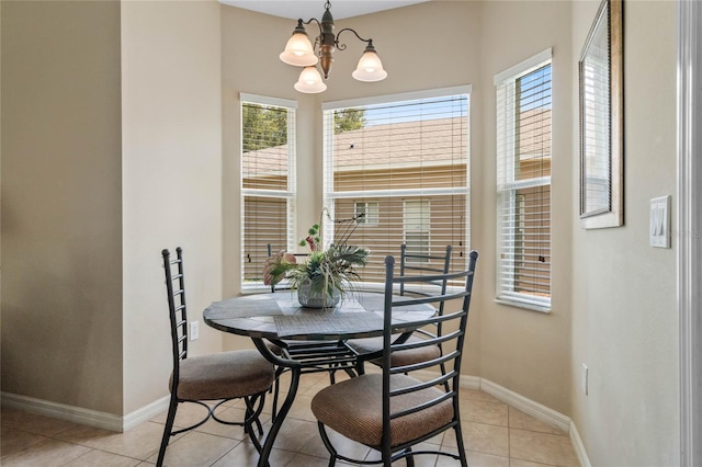 dining area featuring light tile patterned floors, baseboards, and a chandelier