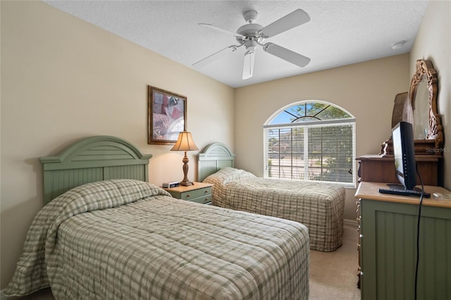 bedroom featuring light carpet, a textured ceiling, and a ceiling fan