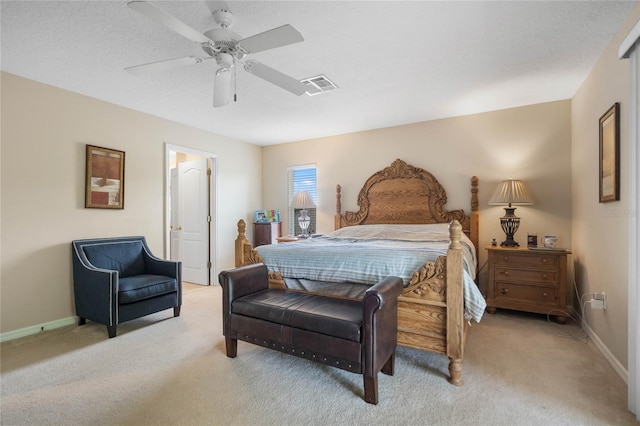 bedroom with visible vents, light colored carpet, baseboards, and ceiling fan