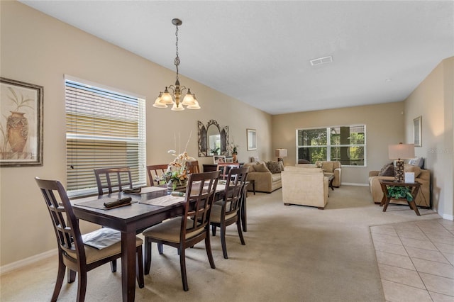 dining area featuring a notable chandelier, baseboards, visible vents, and light carpet