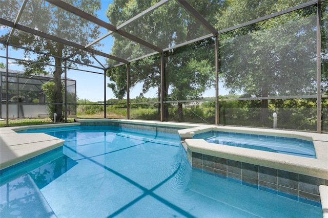 view of pool with glass enclosure and a pool with connected hot tub