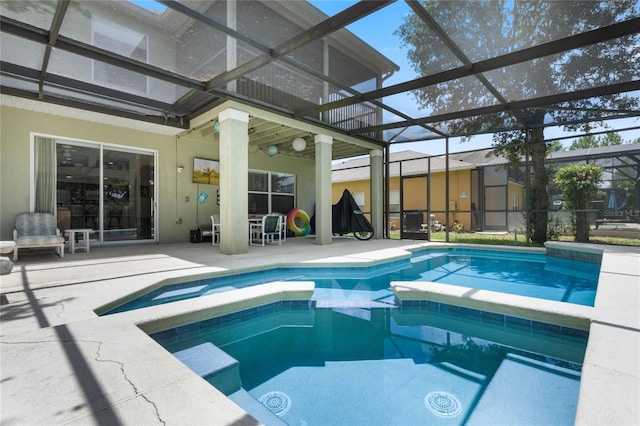 view of pool featuring glass enclosure, a patio, and a pool with connected hot tub