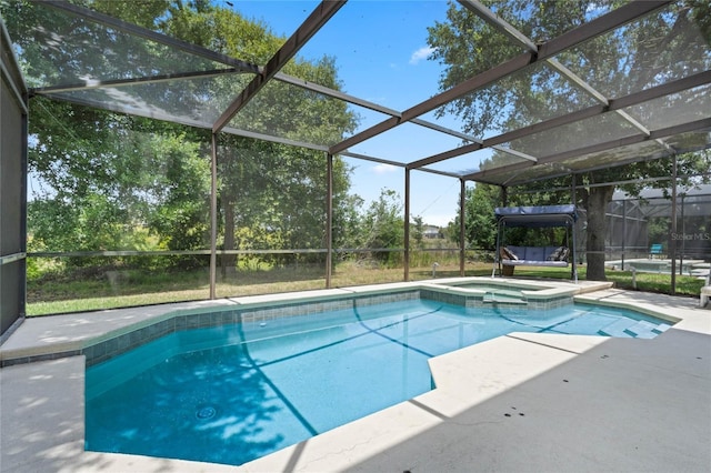 view of pool featuring glass enclosure, a patio area, and a pool with connected hot tub