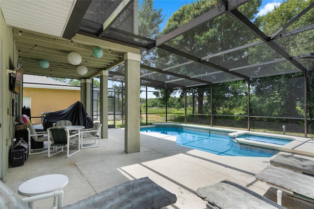 view of swimming pool with a patio, a pool with connected hot tub, and a lanai