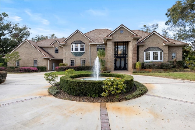 traditional-style house with brick siding and curved driveway