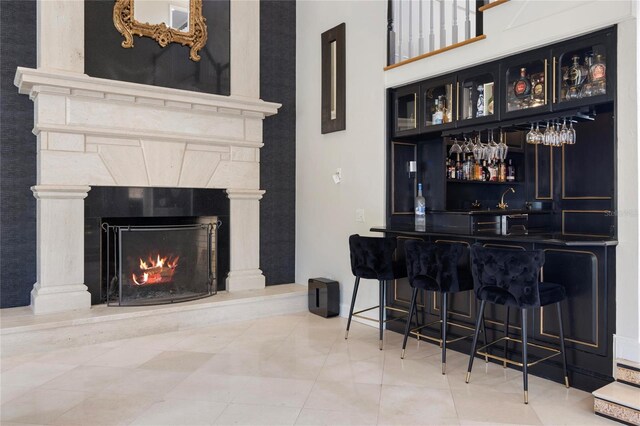 bar with indoor wet bar and a fireplace