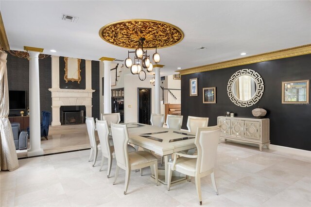 dining space with visible vents, stairway, a fireplace, decorative columns, and an accent wall