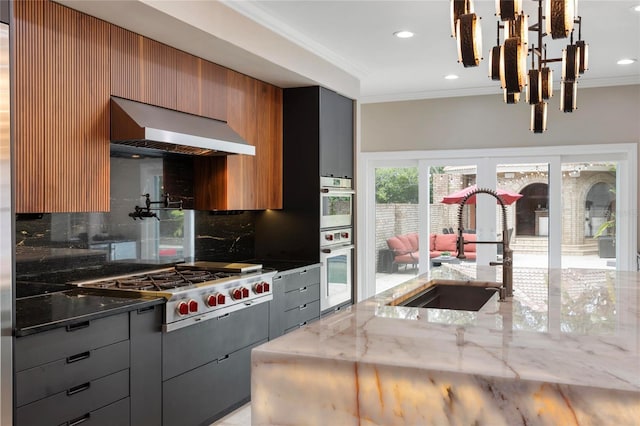 kitchen featuring ornamental molding, a sink, french doors, wall chimney range hood, and decorative backsplash