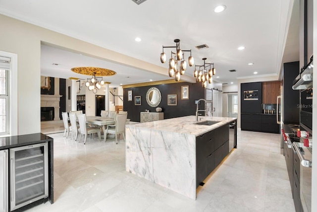 kitchen with visible vents, modern cabinets, beverage cooler, a sink, and a barn door