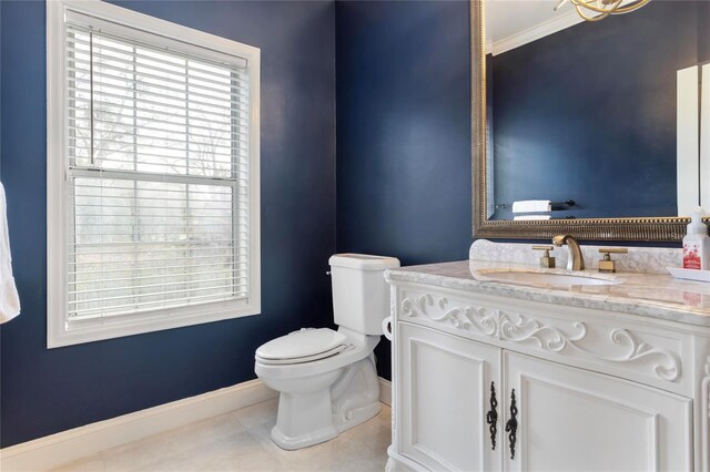 half bath featuring tile patterned flooring, toilet, vanity, and baseboards