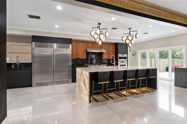 kitchen featuring under cabinet range hood, appliances with stainless steel finishes, and modern cabinets