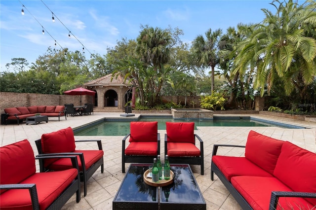 view of swimming pool featuring an outdoor living space, a patio, a pool with connected hot tub, and a fenced backyard