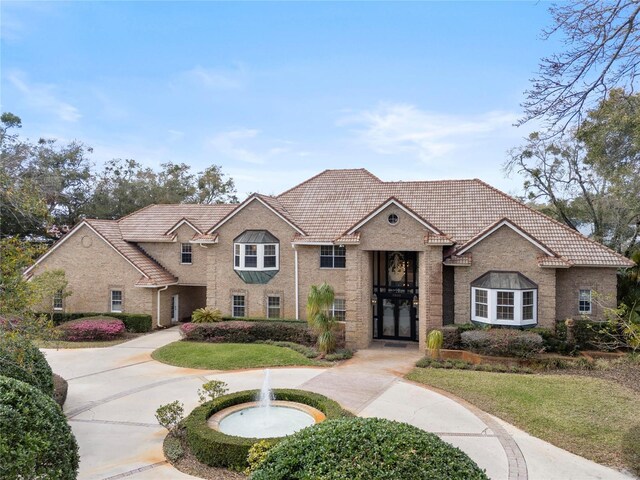 view of front of home featuring a tiled roof and brick siding