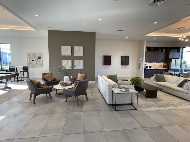 living room featuring visible vents, recessed lighting, baseboards, light tile patterned floors, and a raised ceiling