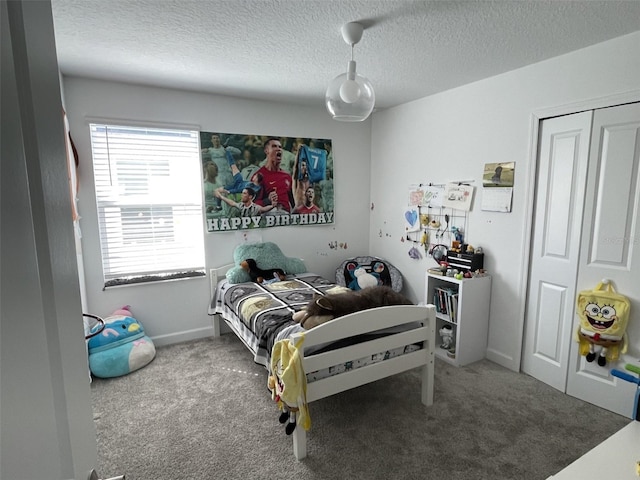 carpeted bedroom featuring a textured ceiling and baseboards