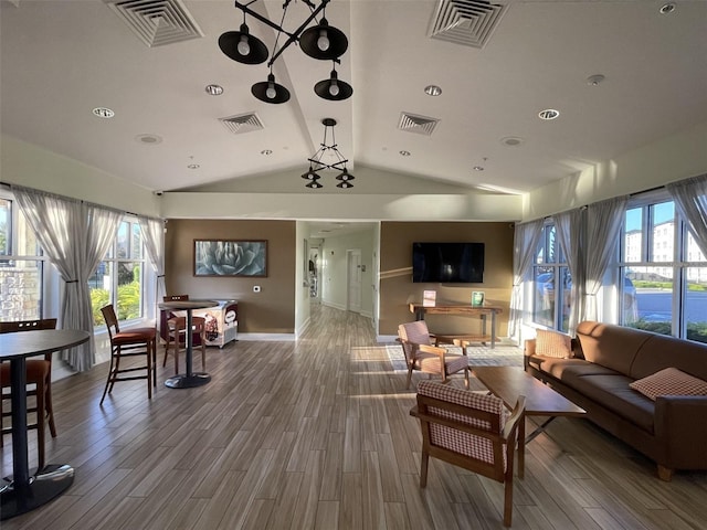 living room featuring visible vents, lofted ceiling, and wood finished floors